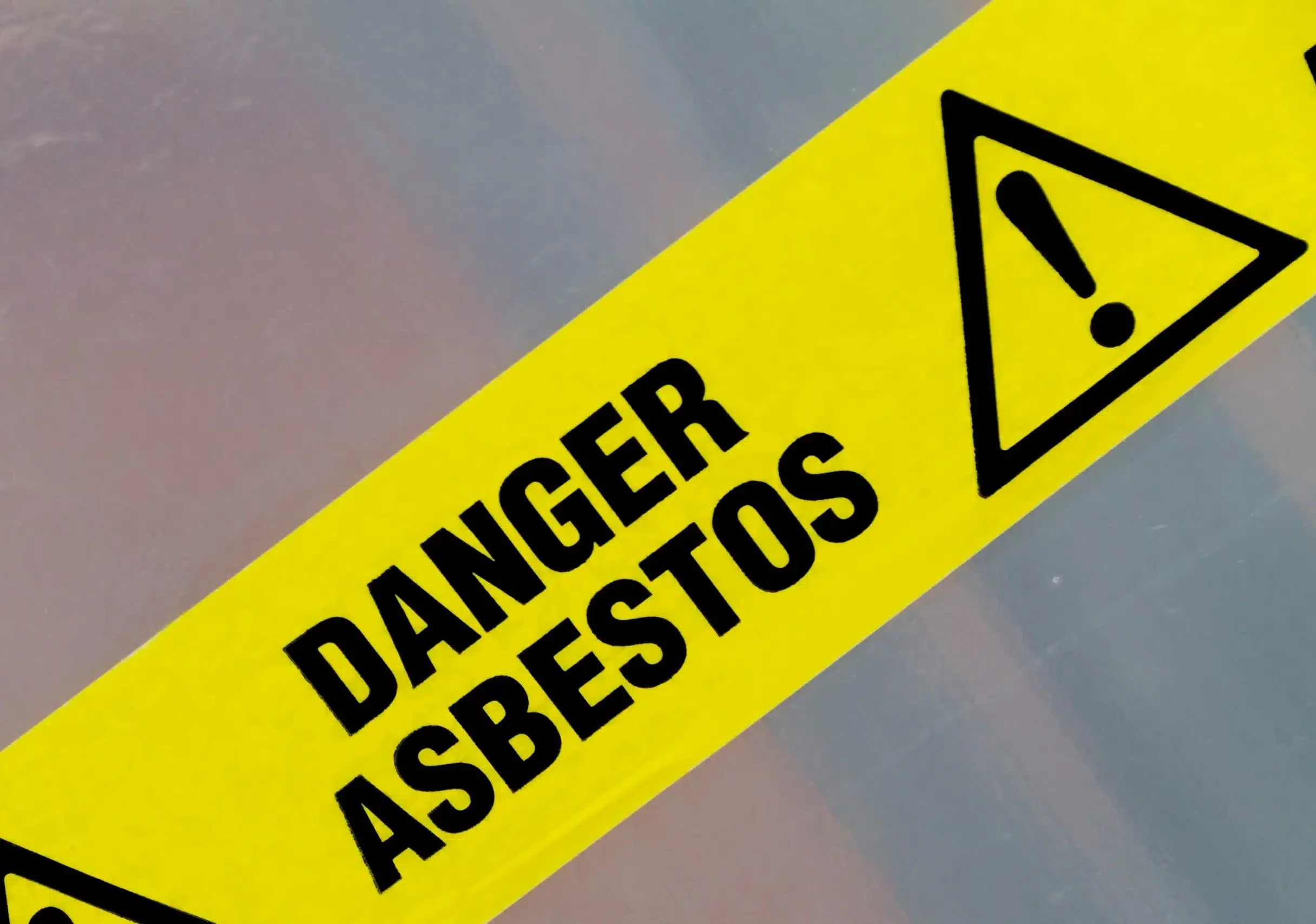 Yellow asbestos hazard warning sign with exclamation mark