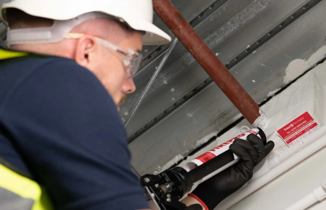 Certified technician installing a fire stopping system